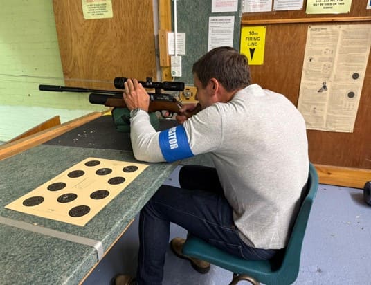 Scott shooting at an indoor target range